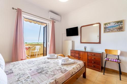a bedroom with a bed and a dresser and a mirror at Lotus Apartment 4 in Almiros Beach