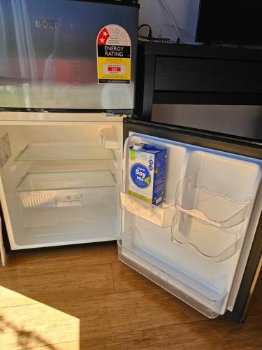 an open refrigerator with a box of milk in it at Private guest suite in Perth