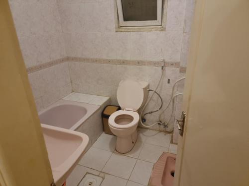 a bathroom with a toilet and a tub and a sink at شقه in Ţāb Kirā‘