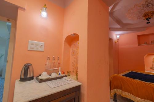 ein Badezimmer mit orangefarbenen Wänden und einer Theke mit einem Waschbecken in der Unterkunft Sheel Mahal- Near Hawa Mahal in Jaipur