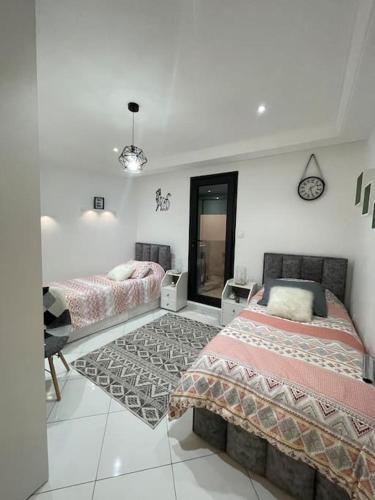 um quarto com 2 camas e um espelho em appartement luxueux a hydra em Alger