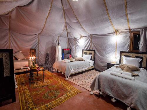 a bedroom with two beds in a tent at Global Luxury Camp in Merzouga
