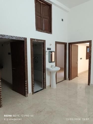 Cette chambre comprend une salle de bains pourvue d'un lavabo et de toilettes. dans l'établissement Kailash home, à Deoghar