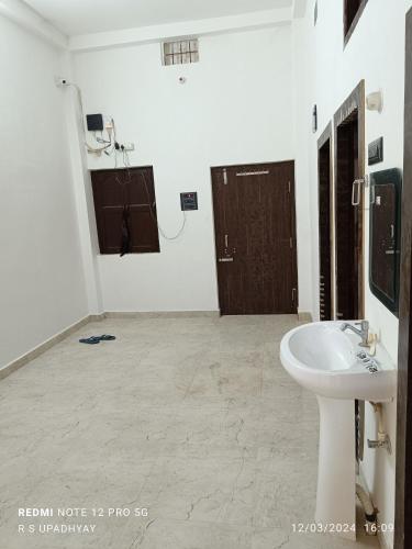 a white bathroom with a sink and a mirror at Kailash home in Deoghar