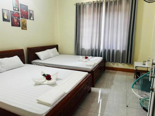 ドンホイにあるView Nhat Le Beach Hotelの花が飾られたベッド2台が備わる客室です。