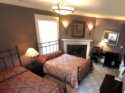 a hotel room with two beds and a television at Longwood Inn in Brookline