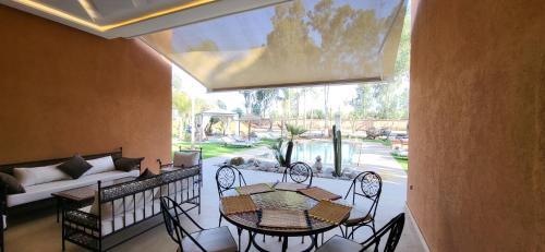 a balcony with a table and chairs and a couch at Le jardin de Jeanne in Marrakech