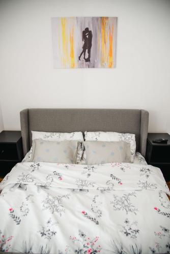 a bed in a bedroom with a painting on the wall at Čudna šuma apartmani Vrdnik in Vrdnik