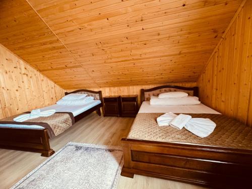 a room with two beds in a wooden cabin at Holi Day in Solotvyno