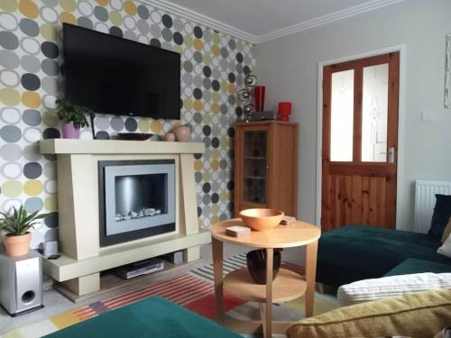 a living room with a television and a table at House with free parking and large garden in Wyke Regis