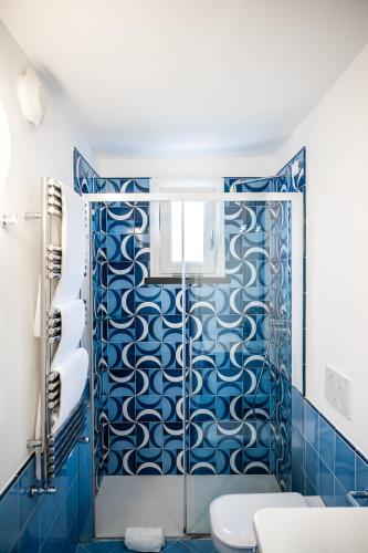 a blue bathroom with a shower with blue tiles at La Divina Amalfi Coast in Praiano