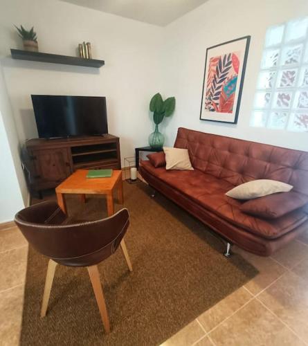 a living room with a brown leather couch and a table at Apartamento Terracota Charco del Pino in Tamaide