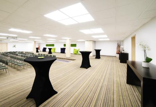 a conference room with black tables and chairs at Novotel Genève Centre in Geneva