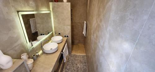 a bathroom with two toilets and a sink and a mirror at Le jardin de Jeanne in Marrakech