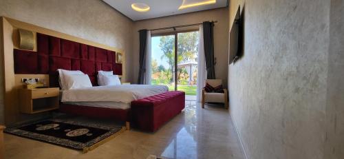 a bedroom with a large bed with a red headboard at Le jardin de Jeanne in Marrakech