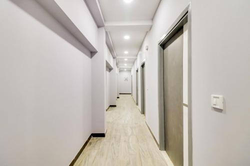 un couloir d'un immeuble de bureaux avec des murs blancs et du parquet dans l'établissement Super OYO Flagship HOTEL DREAM STAY, à New Delhi