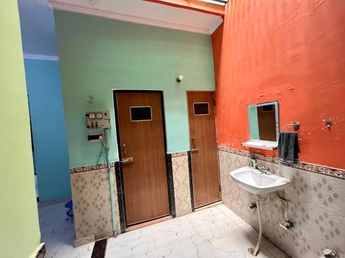 y baño con lavabo y espejo. en Sainik Homestay, Ayodhya en Ayodhya