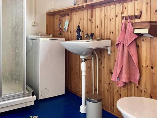 a bathroom with a sink and a washing machine at Holiday home Nösund VI in Nösund