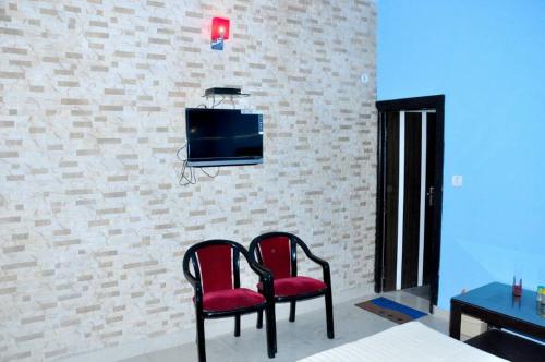 two chairs and a tv on a brick wall at Hotel Tourist Bar & Restaurant in Agra