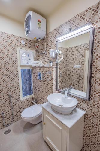 a bathroom with a sink and a toilet and a mirror at Sheel Mahal- Near Hawa Mahal in Jaipur