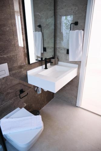 a bathroom with a white sink and a toilet at Ashta Suites / Color Block in Fethiye