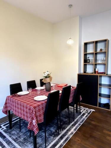 une table à manger avec des chaises et un tissu de table rouge dans l'établissement Appartement de charme, à Autun