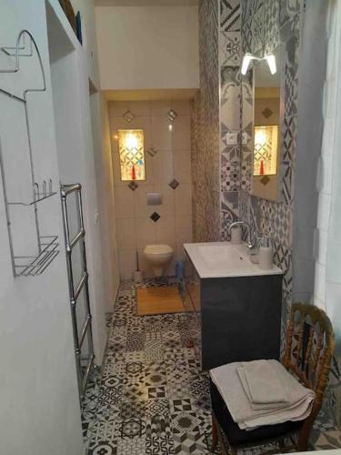 une salle de bain avec un lavabo et des toilettes dans l'établissement Appartement de charme, à Autun