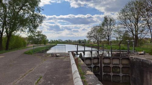 a bridge over a river next to a body of water at Le Gîte de Jade in Dannemarie