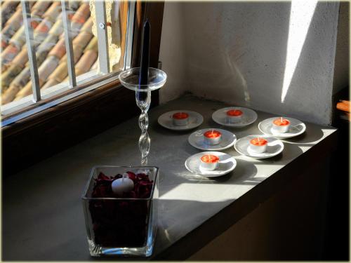 un tavolo con piatti e un vaso di vetro con candele di Il Palazzo del Barone - Stanza dei Maiorana a Pietrapertosa