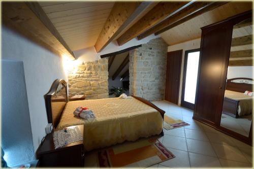 ein Schlafzimmer mit einem Bett in einem Zimmer in der Unterkunft Il Palazzo del Barone - Stanza dei Maiorana in Pietrapertosa