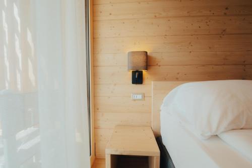 1 dormitorio con cama, lámpara y mesa en Parc Hotel Du Lac en Levico Terme