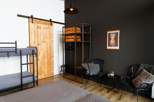 a bedroom with a bunk bed and two chairs at Brouwersdam Stay in Ouddorp