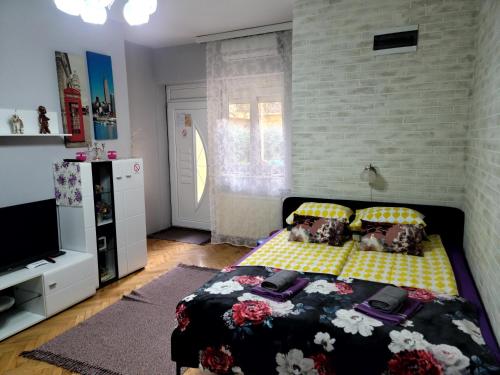 a bedroom with a bed with a black and yellow at Apartment "GARDEN" on Gundulićeva 8 in Novi Sad