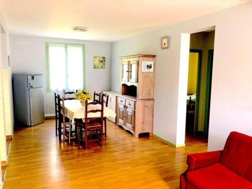- une cuisine et une salle à manger avec une table et un canapé rouge dans l'établissement Appartements 8 personnes, Estaing, à Estaing