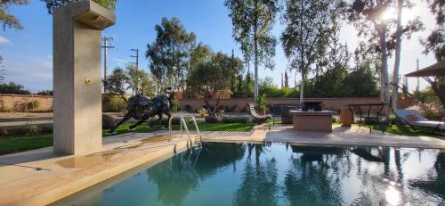 a swimming pool in a yard with a fountain at Le jardin de Jeanne in Marrakech