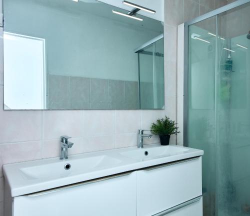een witte badkamer met een wastafel en een spiegel bij Appartement à 10 min de la plage - T4, 9ème in Marseille