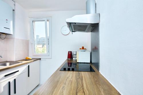une cuisine avec des armoires blanches et un comptoir dans l'établissement Appartement à 10 min de la plage - T4, 9ème, à Marseille
