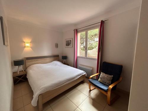 a bedroom with a bed and a chair and a window at Villa 6 personnes 100 m plage 6GSA163 in Le Barcarès