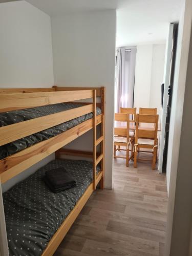 une chambre avec deux lits superposés et une table dans l'établissement Appartement Mediterranée 150m de la Plage, à Canet