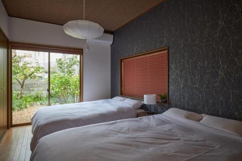 two beds in a bedroom with a window at Walk to Nara Park-Nara's Timeless Stay in Nara
