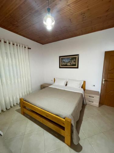 a bedroom with a bed and a wooden ceiling at Rent Rooms Sakolli in Berat