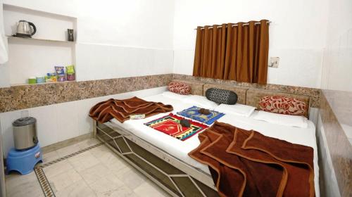 a bed in a room with blankets on it at Hotel Gulshan E Razia Manzil in Ajmer