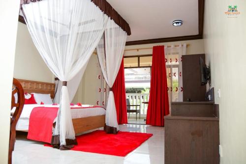 a bedroom with a canopy bed with a red rug at White Peacock Resort in Tezo