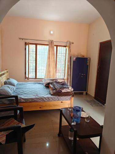 a bedroom with a bed with a window and a table at Rahgir Guest House in Almora