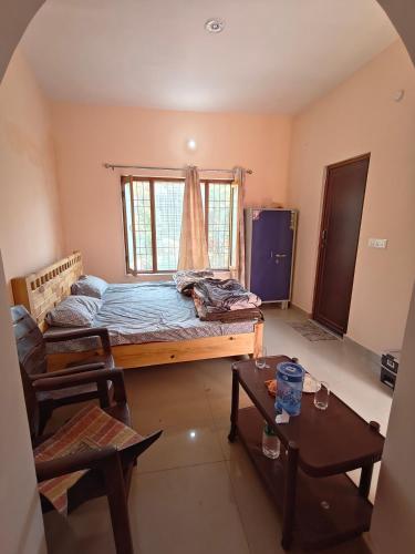 a bedroom with a bed and a window and a table at Rahgir Guest House in Almora