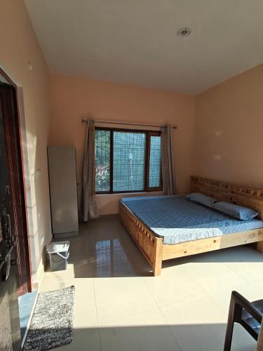 a bedroom with a bed and a large window at Rahgir Guest House in Almora