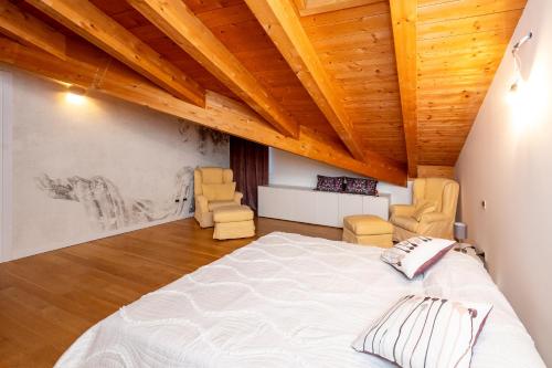 um quarto com uma cama grande e 2 cadeiras em Appartamento Terme Relax em Montegrotto Terme