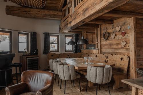 una sala da pranzo con tavolo e sedie in legno di Chalet Lièvre Blanc - LES CHALETS COVAREL a Val dʼIsère