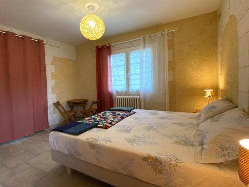 een slaapkamer met een groot bed en een raam bij Yaor Shiatsu Yoga soins, stages, retraites avec jacuzzy in Ladern-sur-Lauquet