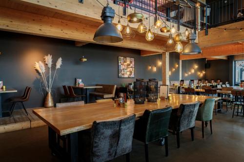 a large dining room with a large wooden table and chairs at Brouwersdam Stay in Ouddorp